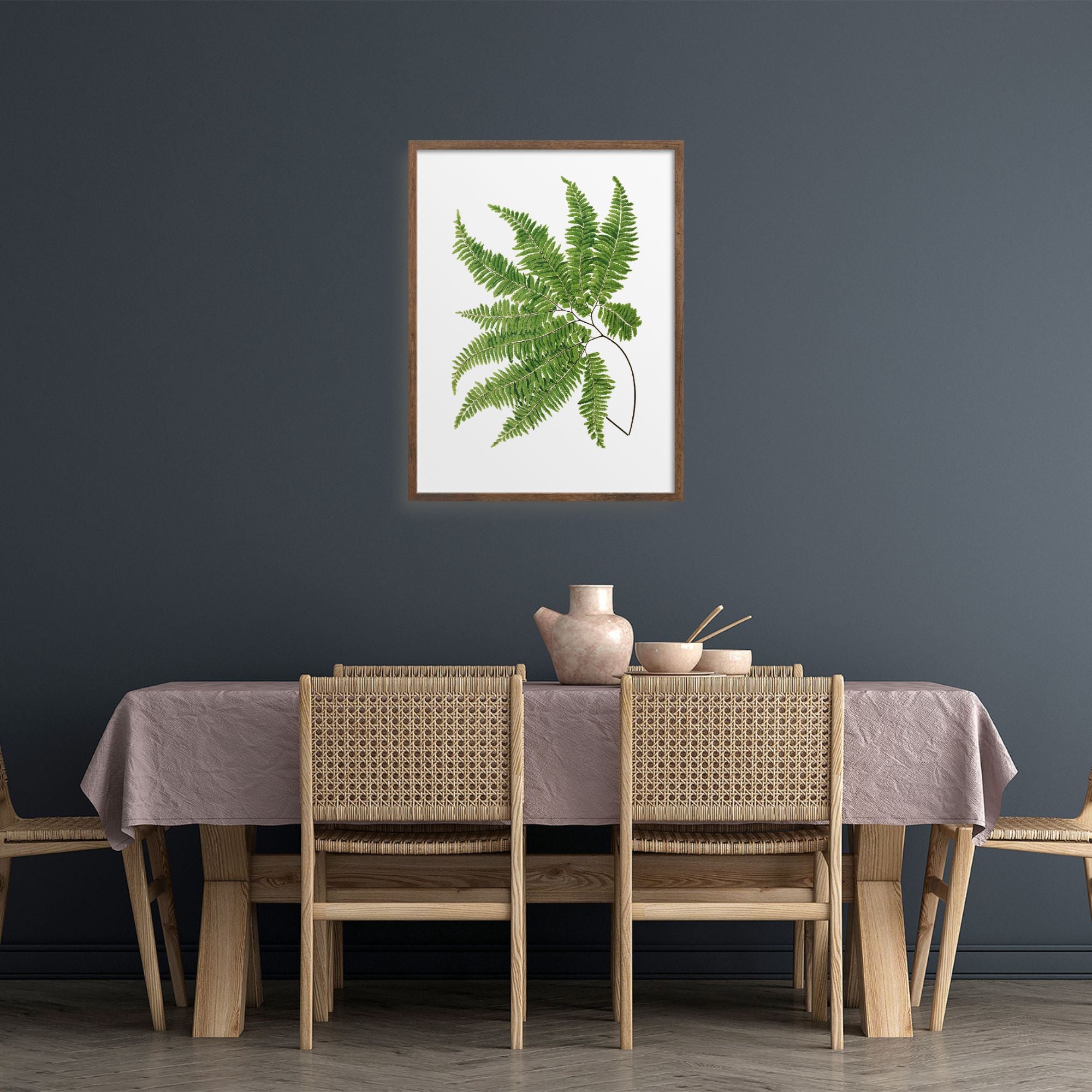 Green fern art print over a dining table.