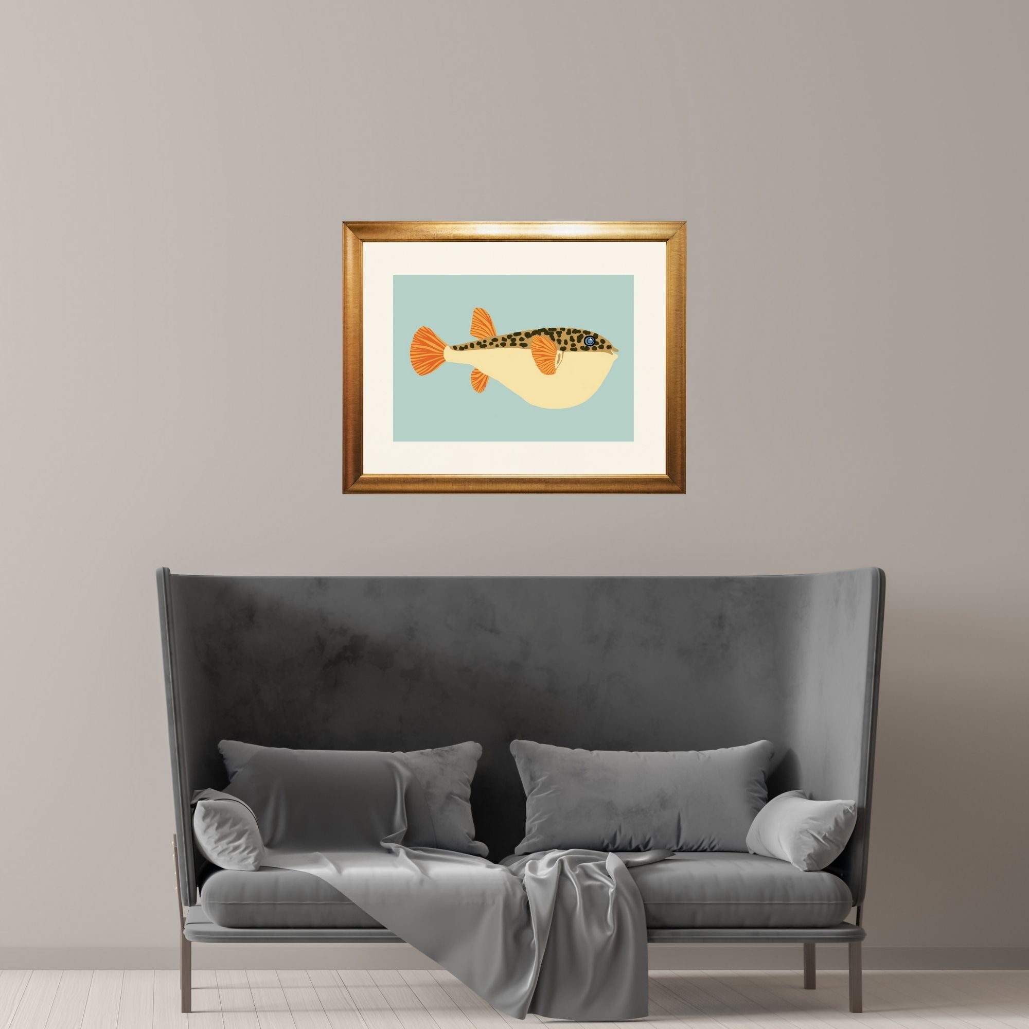 Framed puffer fish over a sofa in a minimalist room.