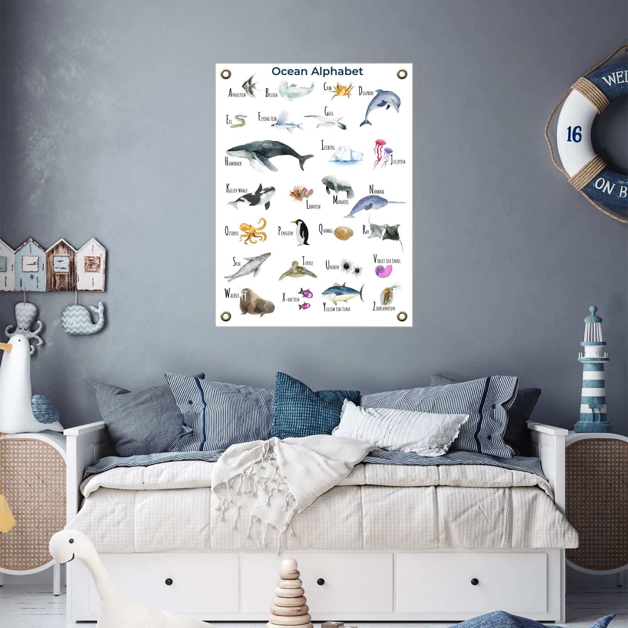 Ocean alphabet poster over a bed in an ocean-themed room