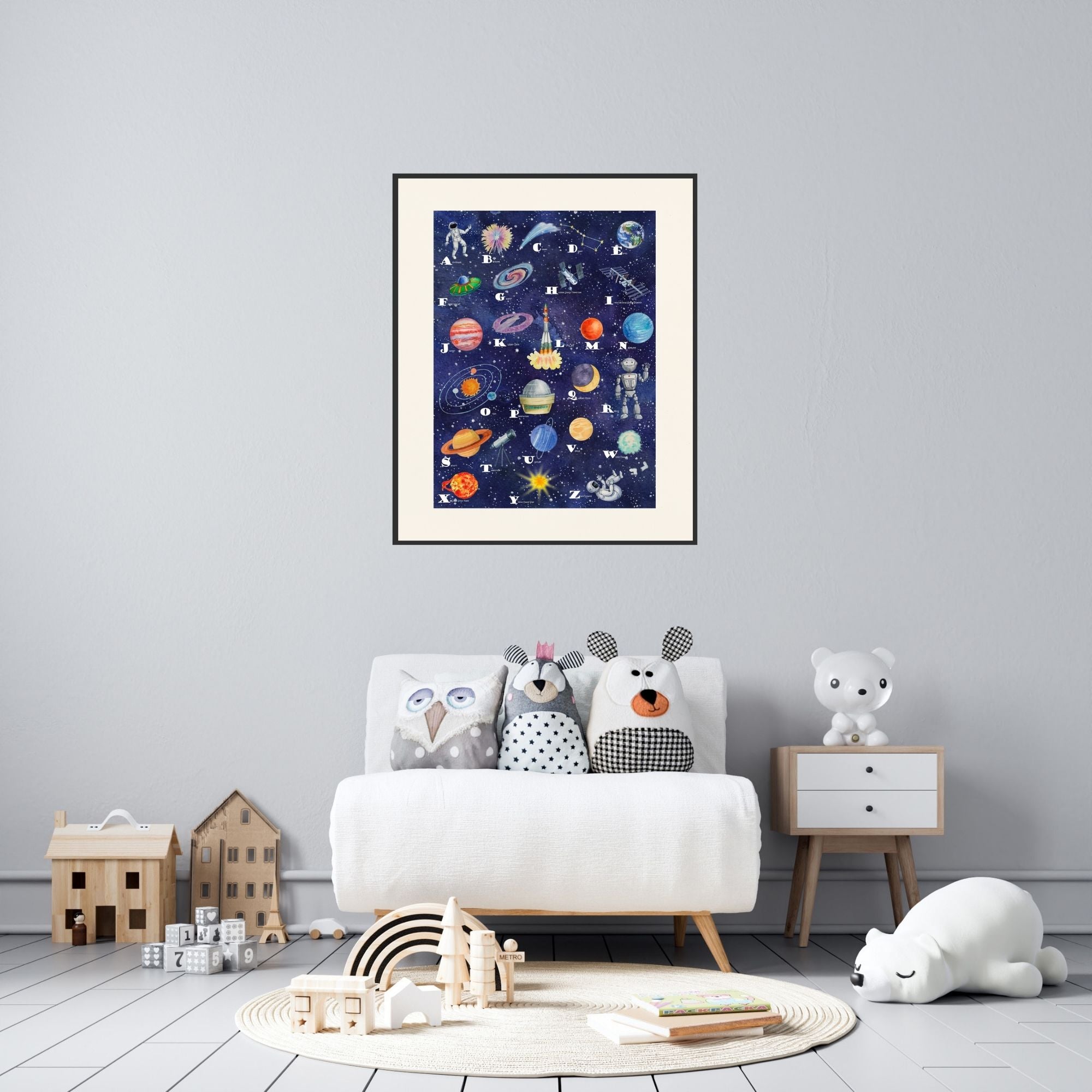 Framed space alphabet poster in a playroom.