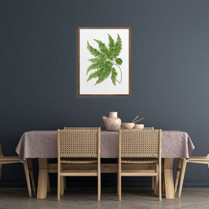 Green fern art print over a dining table. 