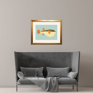 Framed puffer fish over a sofa in a minimalist room. 