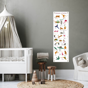 Animal alphabet height chart in child's nursery next to a crib