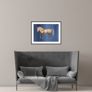 Framed vintage horse over a grey sofa in a minimalist room