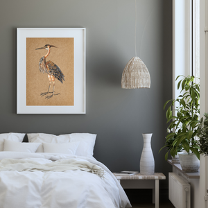 Framed heron over a bed.