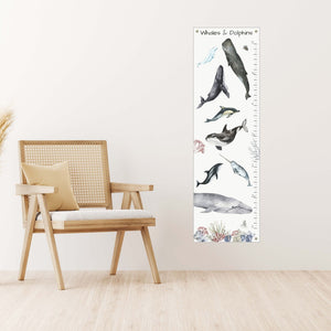 Canvas whale and dolphin growth chart next to a chair.