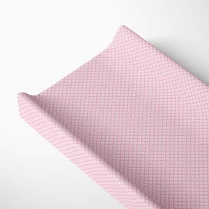 Pink Shibori pattern changing pad cover for baby's nursery.